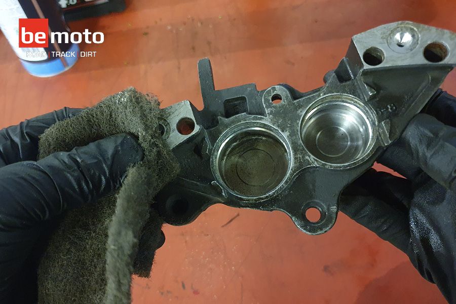 Cleaning a motorcycle brake calliper with Scotchbrite and brake cleaner